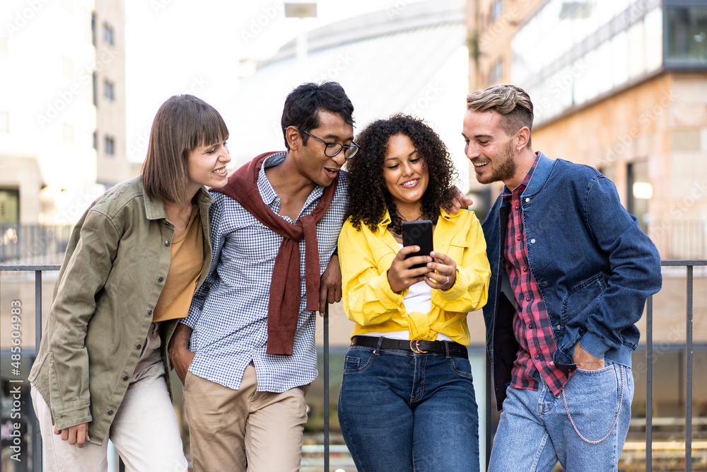Multicultural friends having fun with mobile phone at campus
