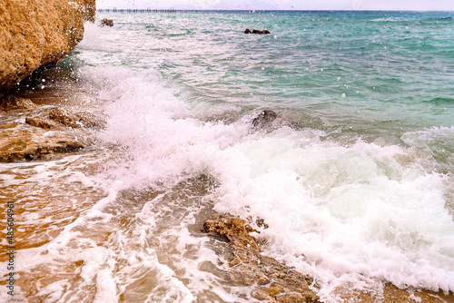 Fototapeta Naklejka Na Ścianę i Meble -  A sea wave with splashes and foam near the shore.