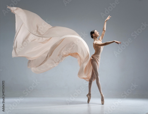 Beautiful ballerina dancing in the body color ballet leotard with body color cloth. She danced on ballet pointe shoes.