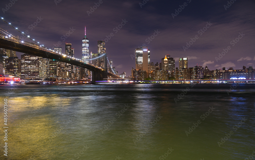 Brooklyn Bridge under the full moon night landscape. This amazing constructions is one of the most known landmarks in New York.