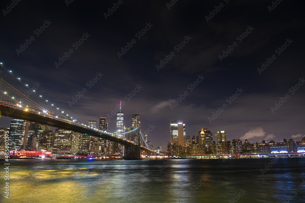 Brooklyn Bridge under the full moon night landscape. This amazing constructions is one of the most known landmarks in New York.