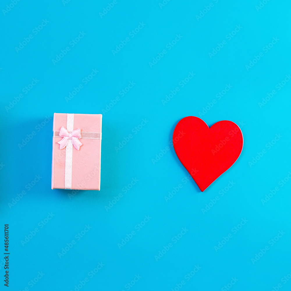 Gift boxes decorated with ribbon and red heart on blue background, copy space. Flat lay, pink and blue present boxes, top view. Valentine or love, spring holidays, Christmas and birthday concept.