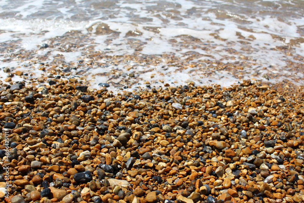 Wet stones from a pebble beach with sea foam - natural texture or background or wallpaper (Brighton Beach, England) Wet stones from a pebble beach with sea foam - natural texture or background or wallpaper (Brighton Beach, England)