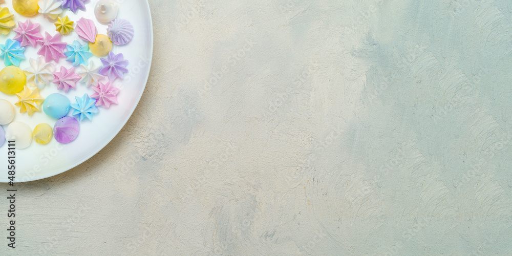Top view of part plate with delicious colorful meringue cookies. Sweet decor. Confectionery Top view of part plate with delicious colorful meringue cookies. Sweet decor. Confectionery