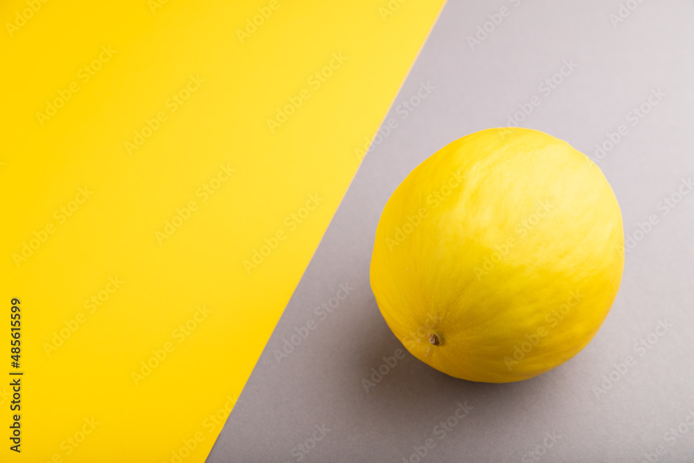 Ripe yellow melon on gray and yellow pastel background. Side view, copy space. Ripe yellow melon on gray and yellow pastel background. Side view, copy space.