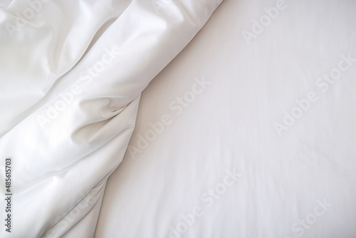 White bedding sheets on bed in bedroom. Morning lifestyle concept.