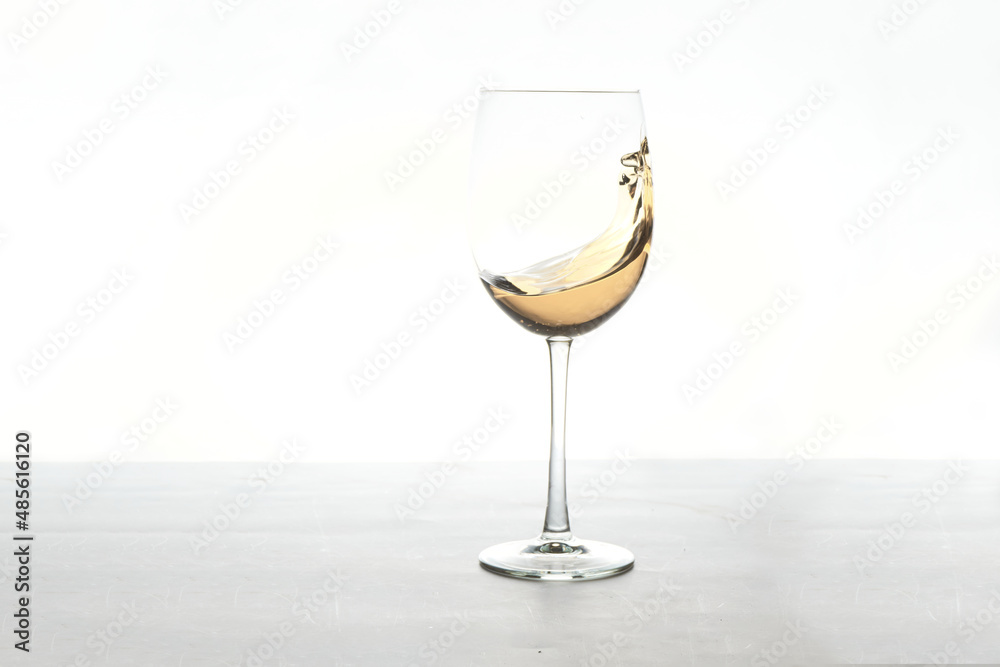 Fototapeta premium glass of white wine splashing on white background