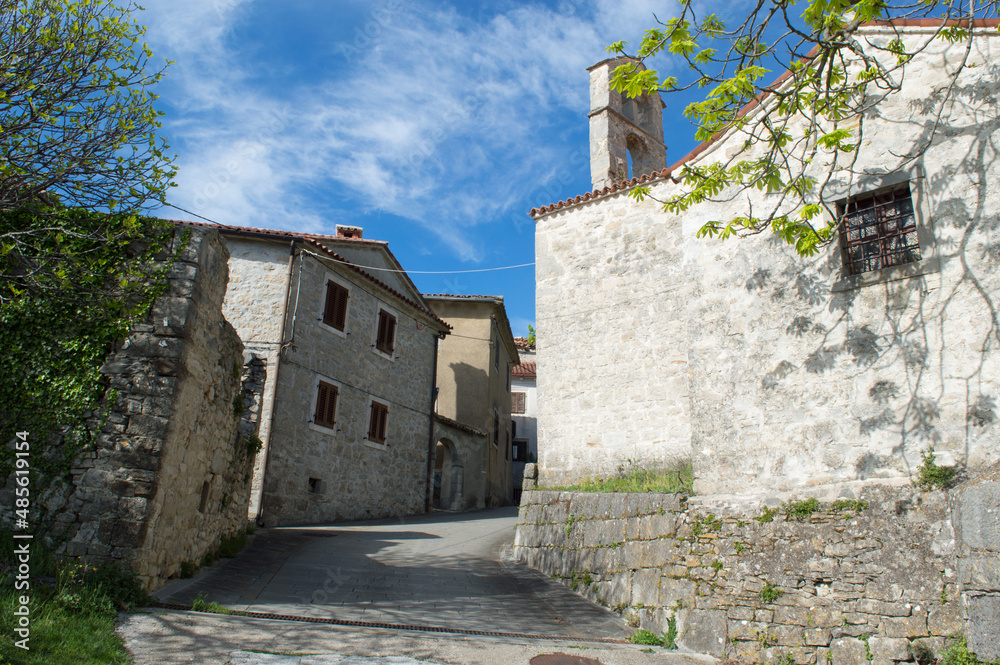 Small ancient town Boljun in norteast Istria, Croatia with characteristic stone houses and a church, both abandoned and renovated houses