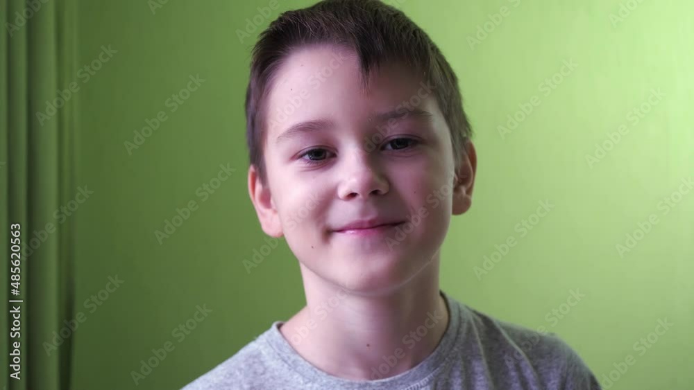 the boy drinks water from a glass. then he looks at the camera and smiles the boy drinks water from a glass. then he looks at the camera and smiles