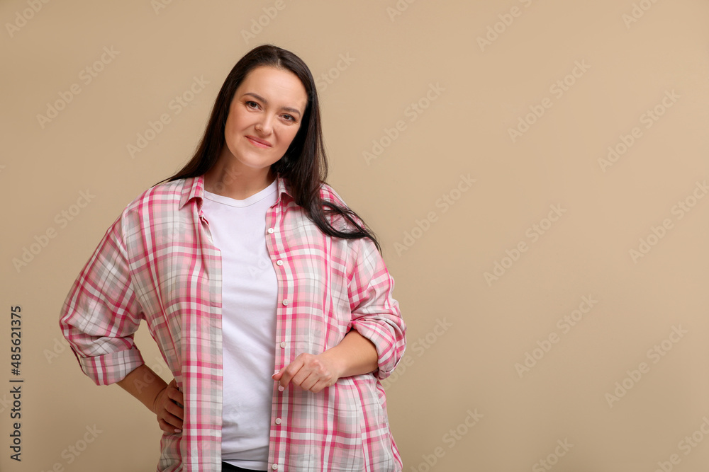 Beautiful overweight woman with charming smile on beige background. Space for text Beautiful overweight woman with charming smile on beige background. Space for text