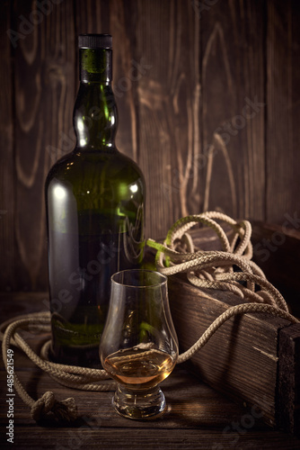 Dark green whisky bottle on a wooden background