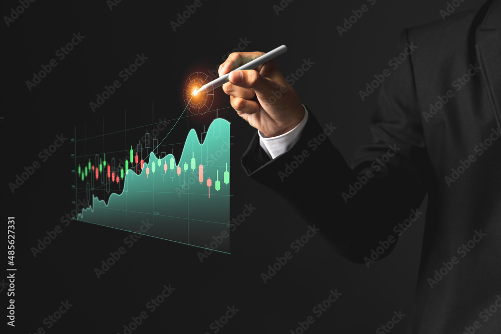 Business man holding pen and showing holographic graphs and stock market statistics gain profits.