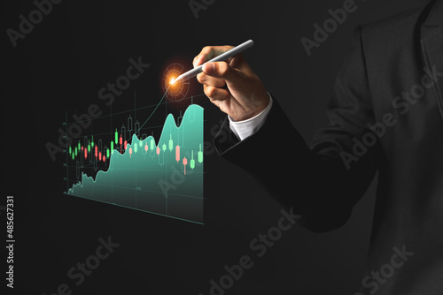 Obraz na płótnie Business man holding pen and showing holographic graphs and stock market statistics gain profits. w salonie