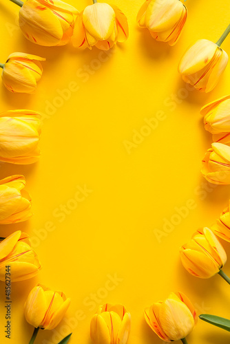 A bouquet of yellow tulips on a yellow background.