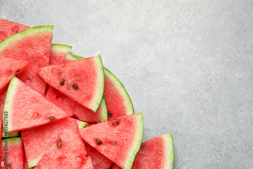 Slices of tasty ripe watermelon on light grey table, flat lay. Space for text