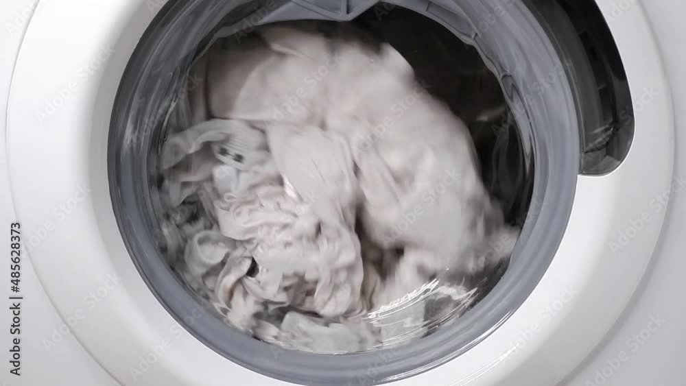 Washing clothes in a washing machine. Slow motion.