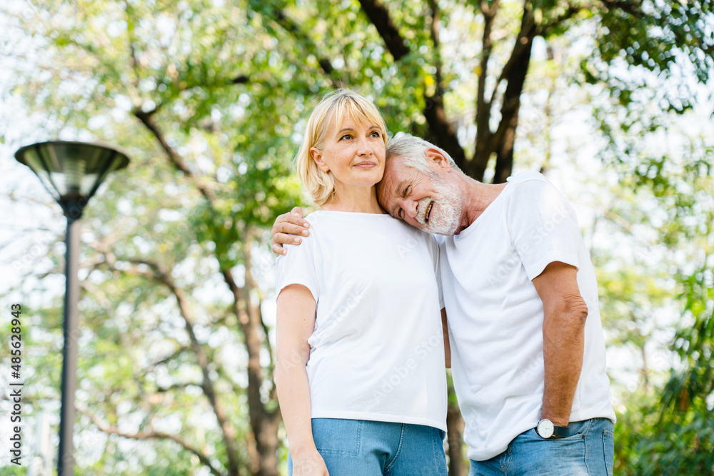 Senior Caucasian couple hugging in park. Family with a happy smile feels relaxed with nature in the morning. Or in the evening. Enter elderly society And retire from work. Concept health insurance Senior Caucasian couple hugging in park. Family with a happy smile feels relaxed with nature in the morning. Or in the evening. Enter elderly society And retire from work. Concept health insurance