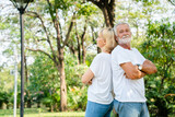 Senior Caucasian couple hugging in park. Family with a happy smile feels relaxed with nature in the morning. Or in the evening. Enter elderly society And retire from work. Concept health insurance