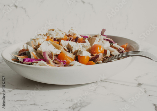 Tofu salad with yellow and red cherry tomatos and noodle in white bowl photo