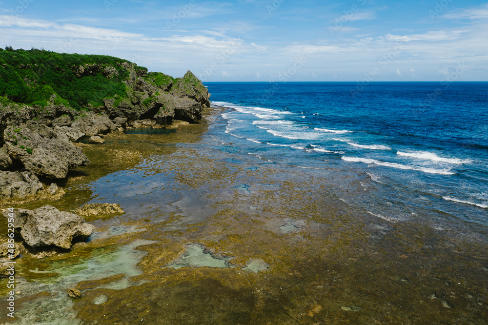 Tide pools, waves and blue ocean cliffs on coastline of island