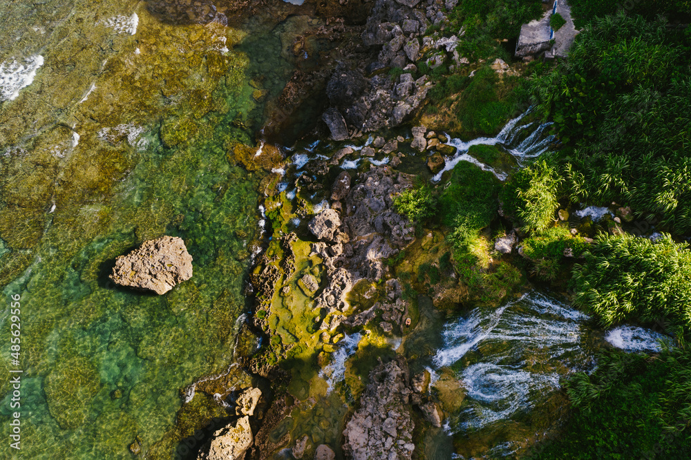 Drone waterfall on coastline of tropical island into tide pools
