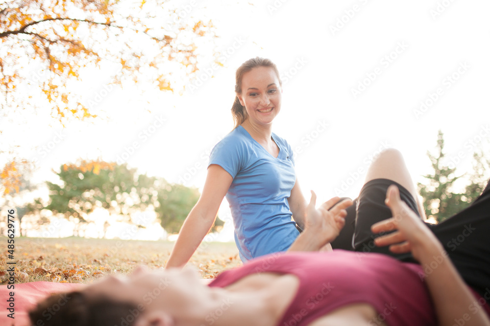 Woman yoga trainer demonstrating to student Woman yoga trainer demonstrating to student