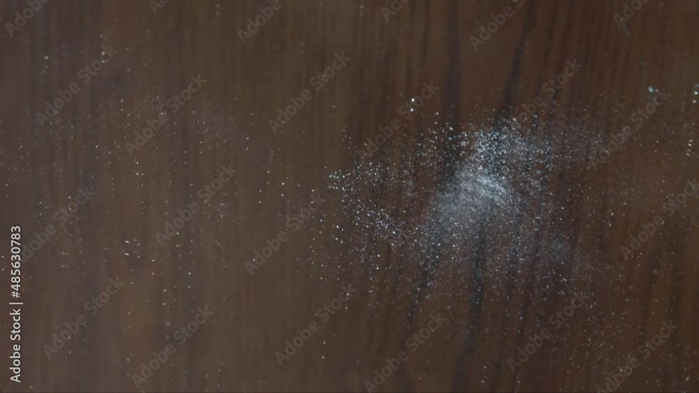 A hammer hitting and breaking a mirror into lots fragments with wooden background