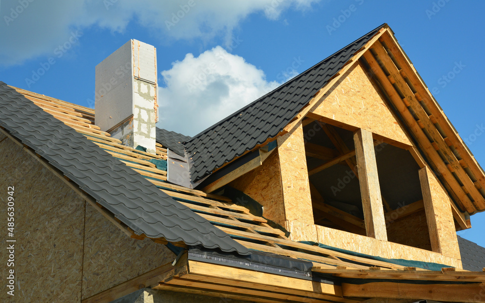 The construction of a metal roof over an attic with installation of a waterproofing flashing in a problem area, roofing valley. Chimney and roofing construction and tiling. The construction of a metal roof over an attic with installation of a waterproofing flashing in a problem area, roofing valley. Chimney and roofing construction and tiling.