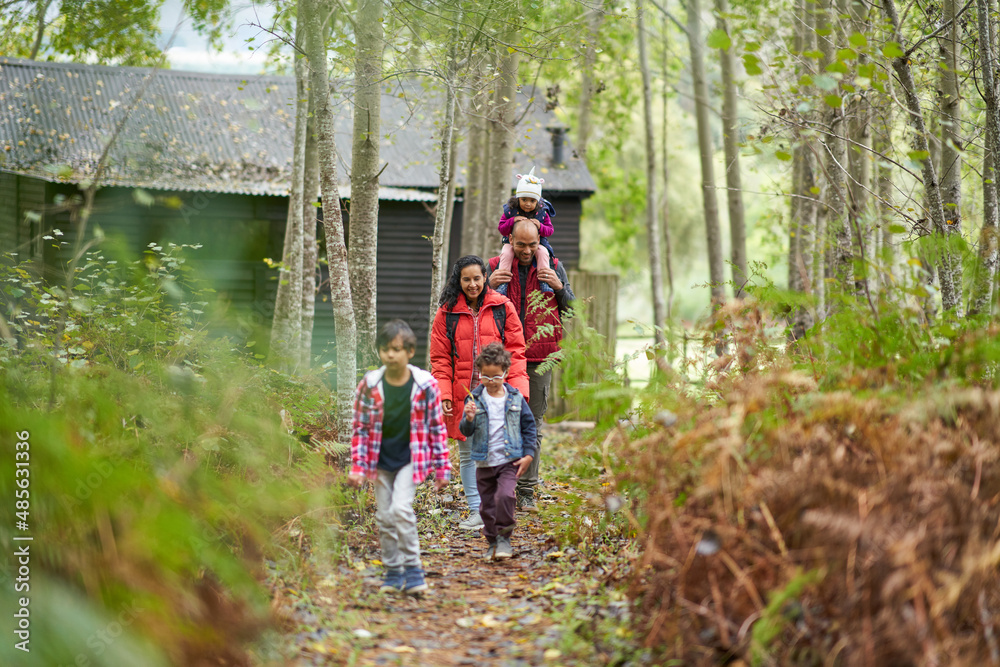 Family hiking on trail in woods outside cabin Family hiking on trail in woods outside cabin