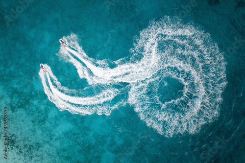 Aerial Top Down View Of People On Jet Skis Racing Around In Circle Formations Across The Blue Ocean Waves In Male, Maldives. photo