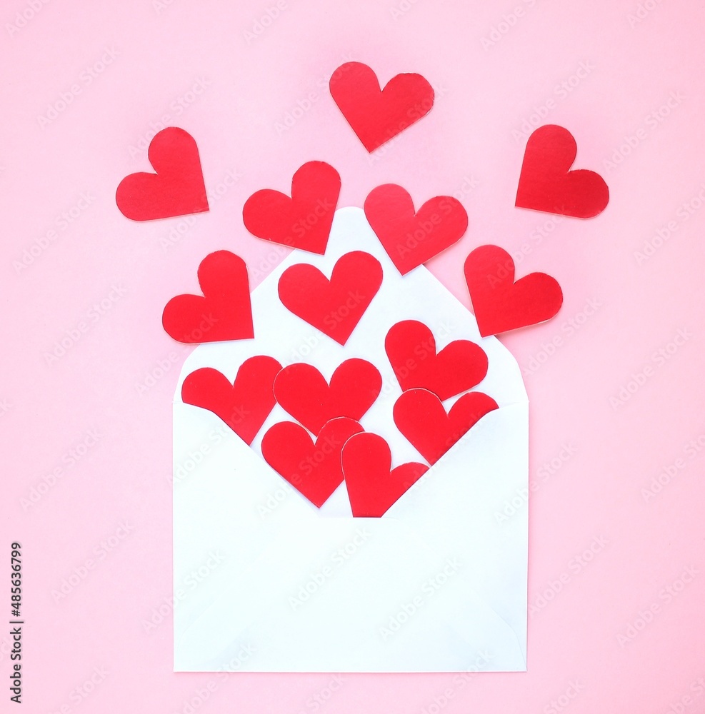 Red hearts and white envelope on pink background. Romantic message, letter, gift, greeting card for Valentine's Day concept. Holiday festive creative design love composition. Flatlay, top view Red hearts and white envelope on pink background. Romantic message, letter, gift, greeting card for Valentine's Day concept. Holiday festive creative design love composition. Flatlay, top view