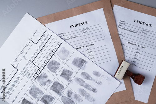 Billede på lærred Fingerprint card and paper envelopes for packaging evidence on  gray background