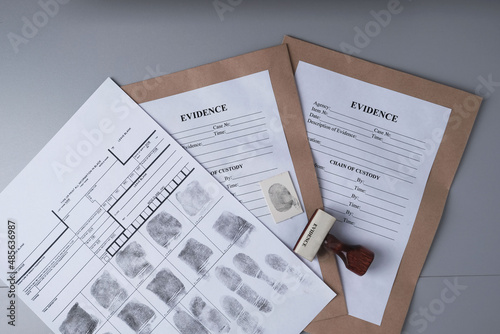 Fingerprint card and paper envelopes for packaging evidence on  gray background