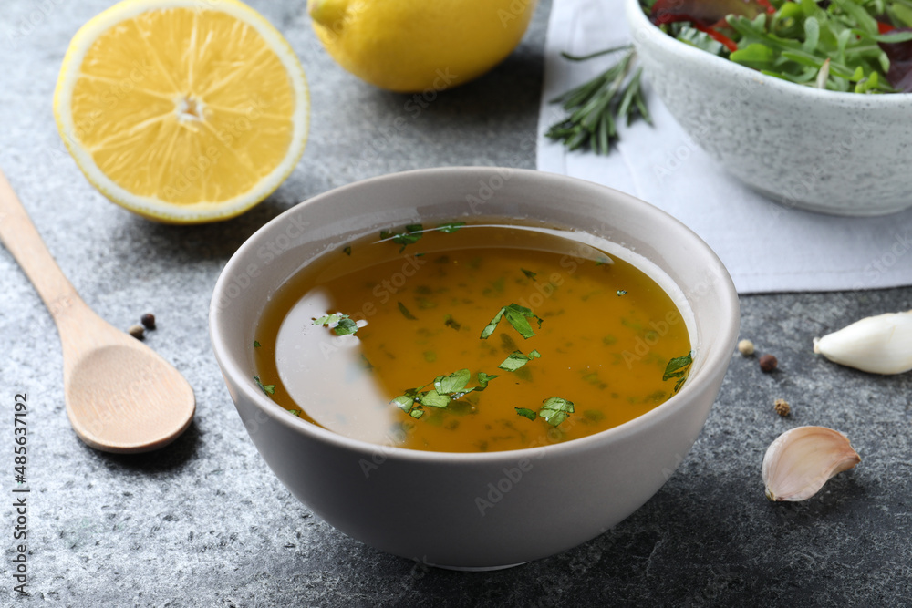 Bowl with lemon sauce on grey table. Delicious salad dressing Bowl with lemon sauce on grey table. Delicious salad dressing