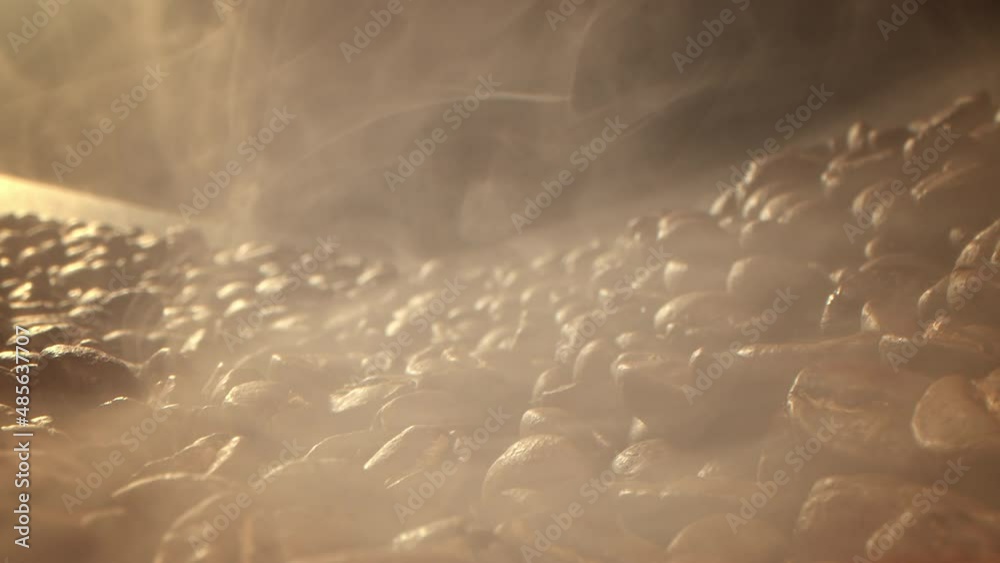 Macro shot roasting coffee beans, filmed in a dark key the smoke ...