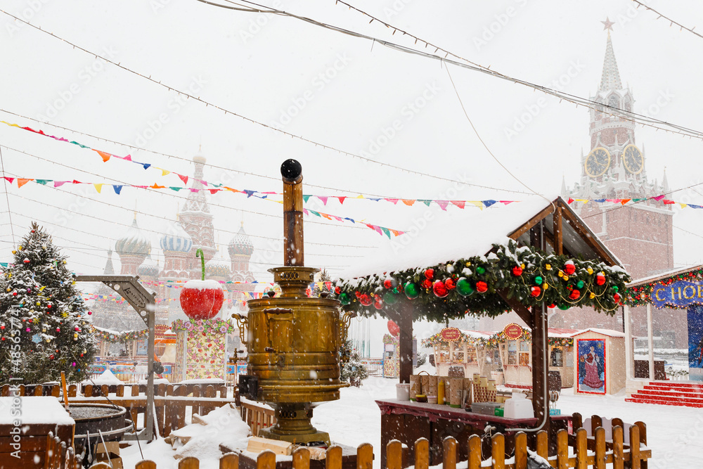 Moscow, Russia, February 7, 2022, Fair on Red Square in winter. Tea from Russian samovar in the street is a national tradition. A view of St. Basil's Cathedral. A picture of Russian winter in light co