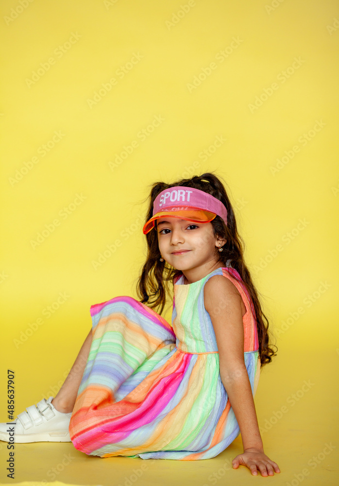 Funny little girl about 6 years old in casual summer clothes posing on a plain yellow background. The concept of a child's lifestyle. Layout of the copy space. Funny little girl about 6 years old in casual summer clothes posing on a plain yellow background. The concept of a child's lifestyle. Layout of the copy space.