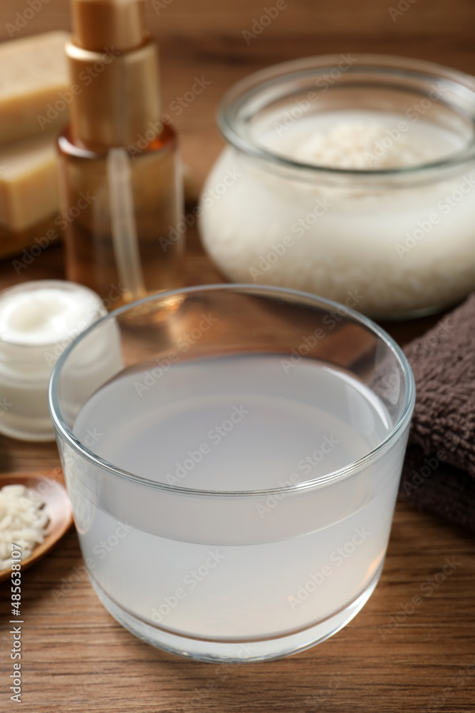 Homemade natural rice water and cosmetic products on wooden table, closeup Homemade natural rice water and cosmetic products on wooden table, closeup