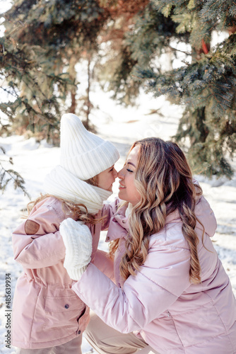 A little daughter and mother gently hug, kiss, showing love and expressing affection.Happy family, the pleasure of being a mom, congratulations on Mother's Day, the concept of a sweet moment together
