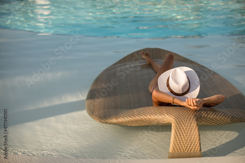 Sexy Woman relaxing at the luxury poolside.