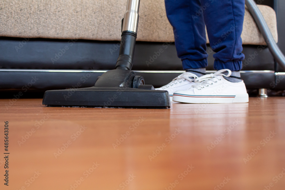 Fototapeta premium Woman using vacuum cleaner to cleaning parquet floor.