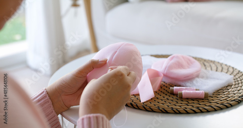 Close-up hand asia woman help make craft pink single fill up bra cup insert for post mastectomy prosthesis surgery MRM at home. Relief work service support give hope to tumor patient medical issue.