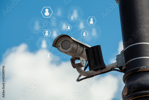 CCD surveillance camera mounted on a pole in the street. Security cam monitoring people for safety purposes. 