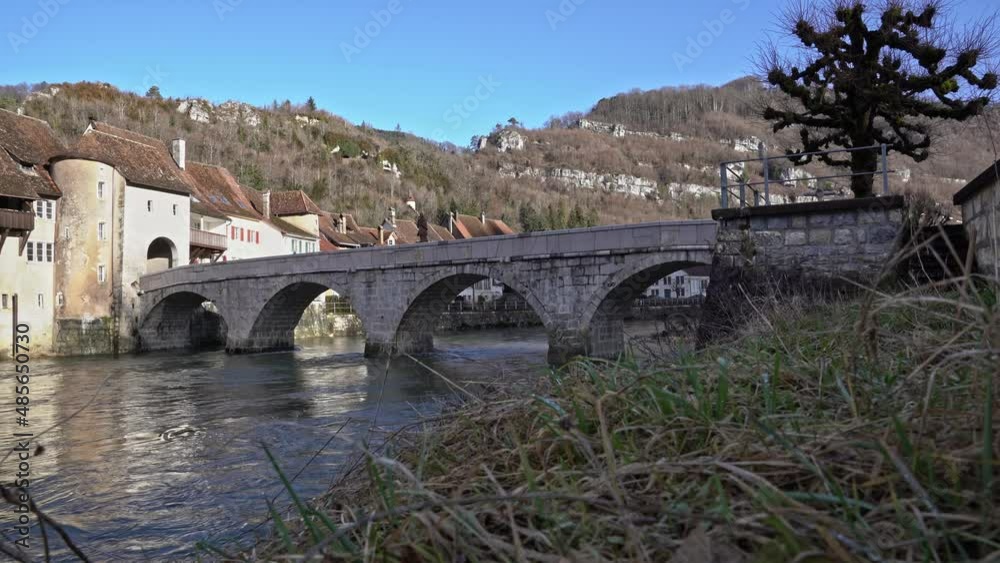 Medieval village Saint-Ursanne, Canton Jura, with beautiful facades of historic houses and stone bridge over river Doubs. Movie shot February 7th, 2022, Saint-Ursanne, Switzerland. Medieval village Saint-Ursanne, Canton Jura, with beautiful facades of historic houses and stone bridge over river Doubs. Movie shot February 7th, 2022, Saint-Ursanne, Switzerland.