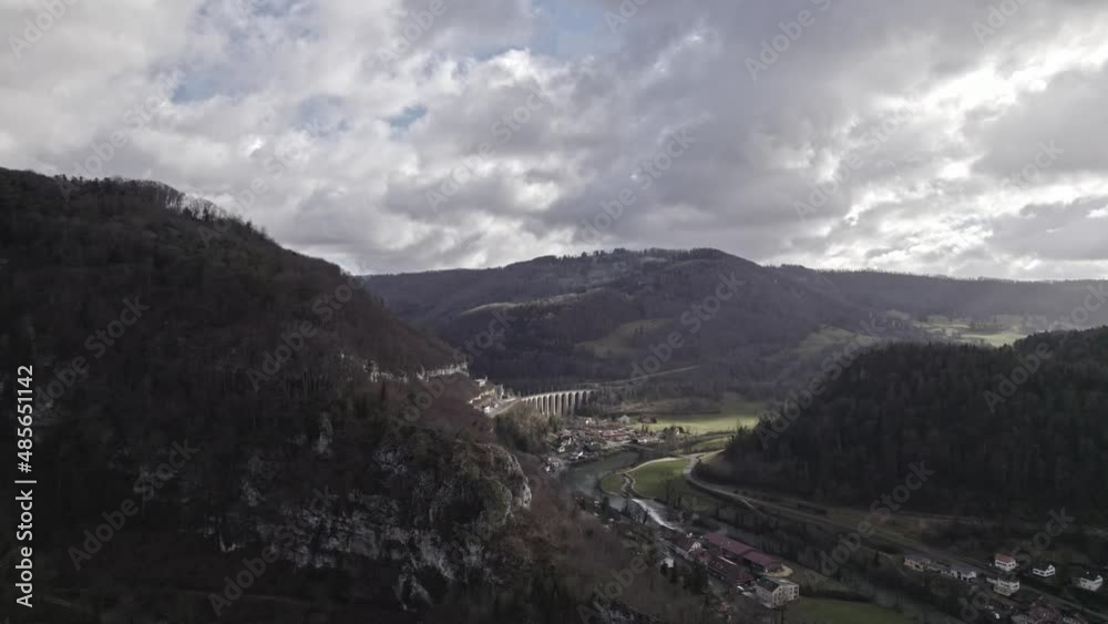 Beautiful landscape at medieval Village Saint-Ursanne, Canton Jura, with railway viaduct and river Doubs. Movie shot February 7th, 2022, Saint-Ursanne, Switzerland.