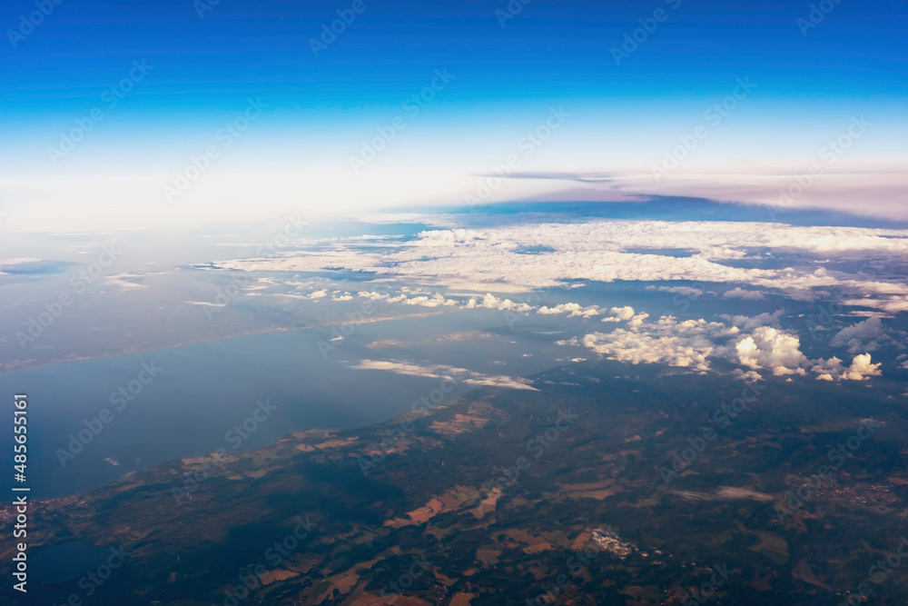View of the earth through the clouds. Flight over lakes and forests. 