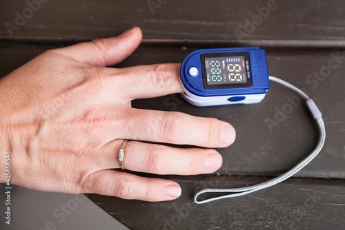 Person using oximeter for monitoring peripheral oxygen saturation, close up view photo