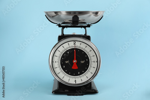 Retro mechanical kitchen scale on light blue background photo