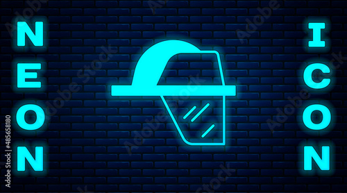 Glowing neon Firefighter helmet or fireman hat icon isolated on brick wall background. Vector