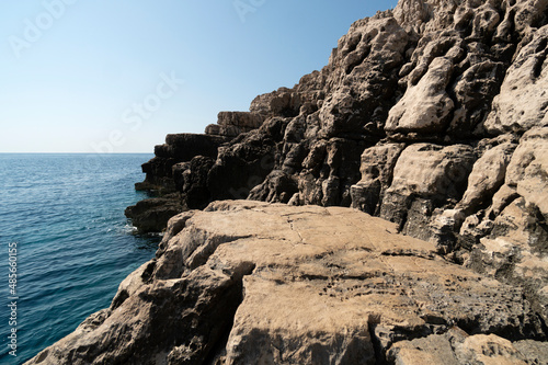 Blue ocean water with waves crashing on the rocky shore